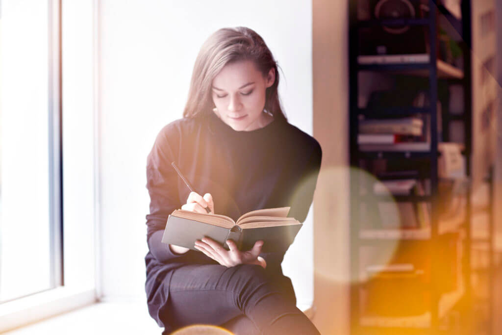 woman writting in book